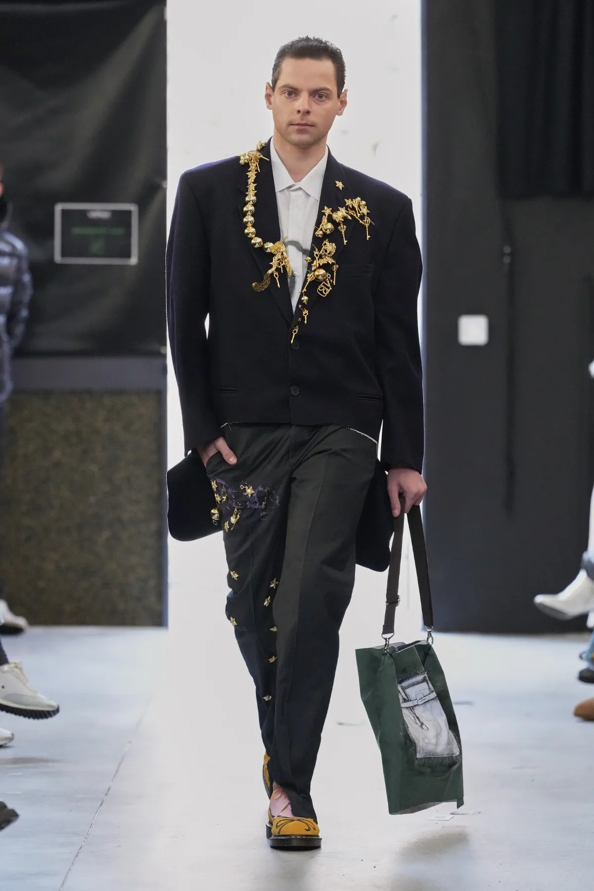 La collection automne 2025 de Simon Cracker critique la mode de luxe