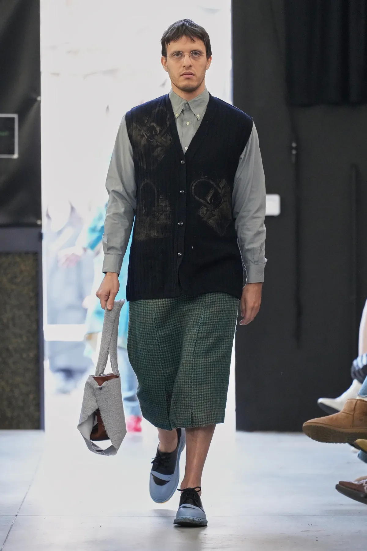 La collection automne 2025 de Simon Cracker critique la mode de luxe